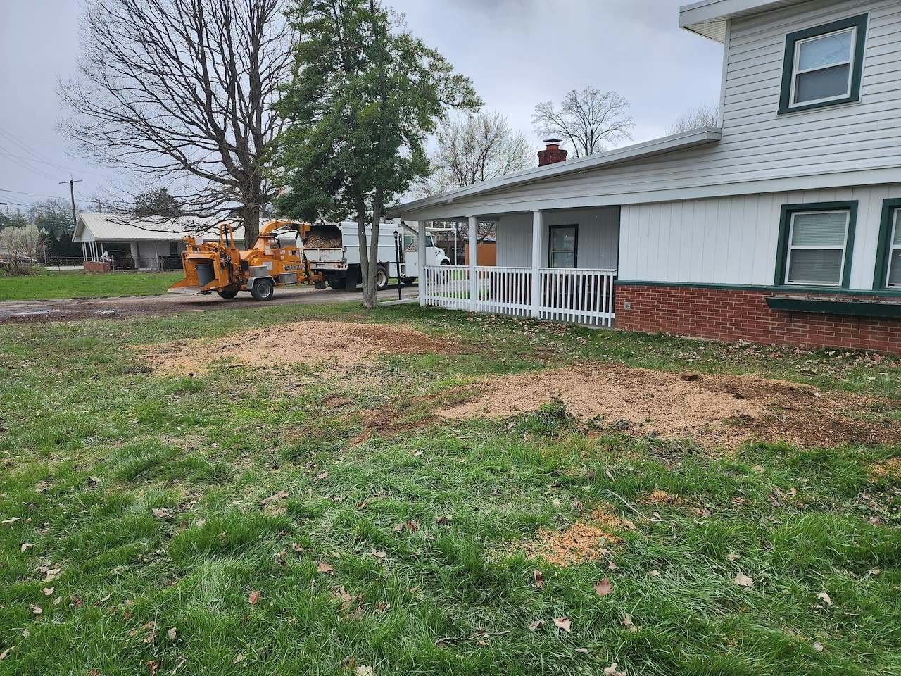 Wood chipper and crew truck at a finished residential job site